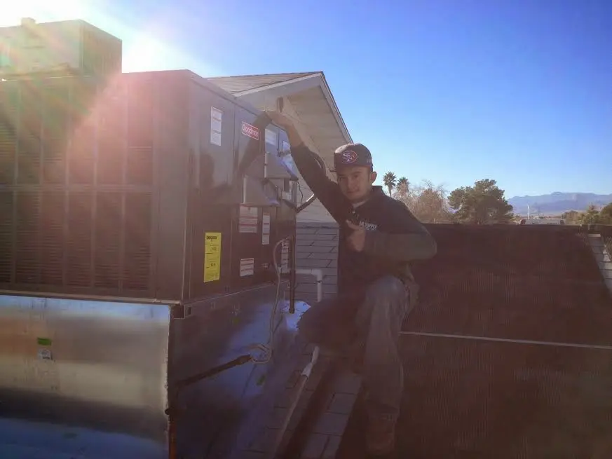 HVAC technician performing Air Duct Cleaning on a rooftop unit in Bellevue